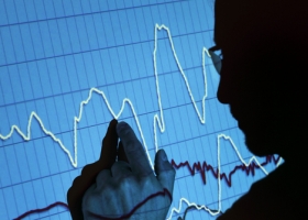 Silhouette of a businessman pointing to a projected graph at a presentation Silhouette of a businessman pointing to a projected graph at a presentation